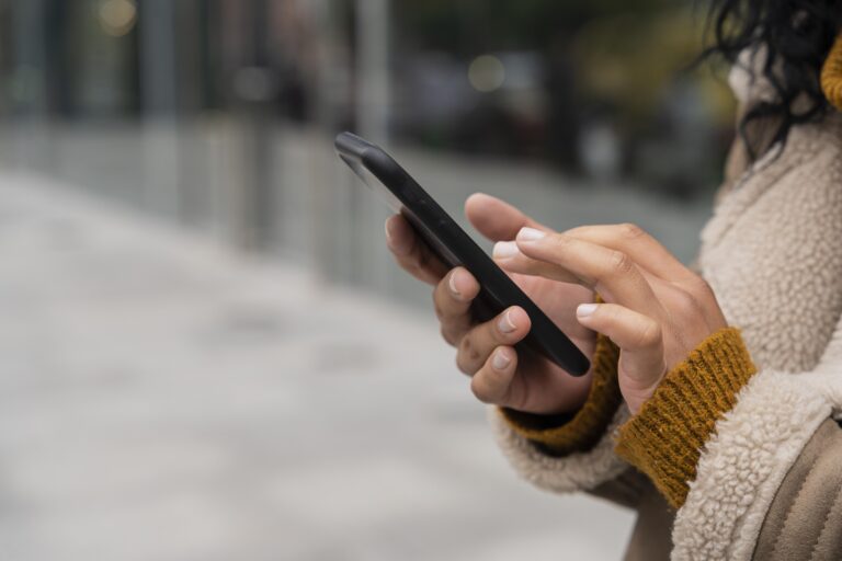 Photo of a woman using her smartphone outside